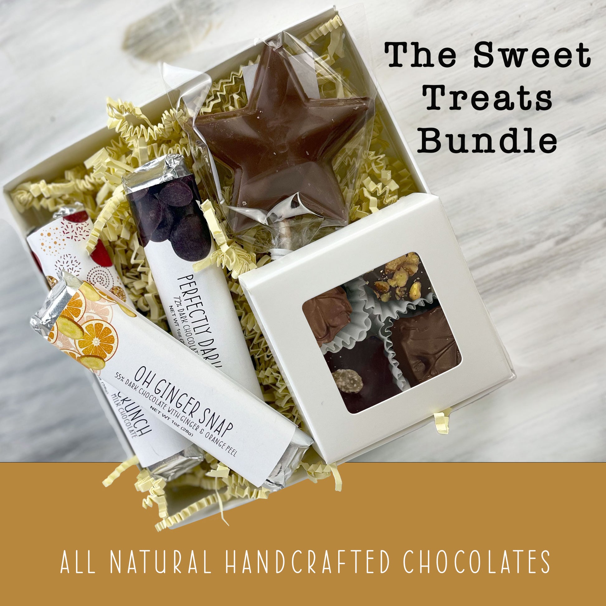 An open square gift box featuring a selection of three assorted snack-size mini chocolate bars, a chocolate lollpop and box of four chocolate covered caramels